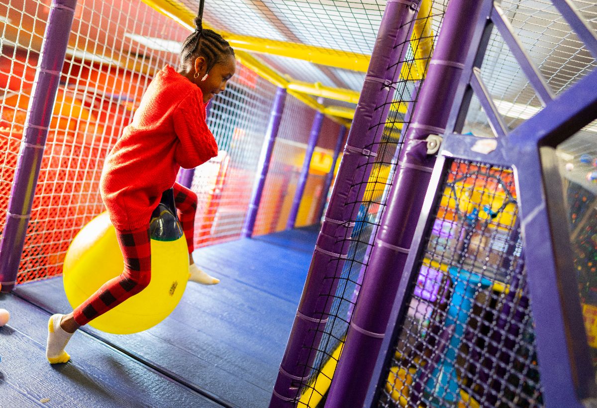 Guest climbing through the Laser Bounce Ballocity play structure